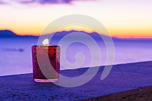 Candle glass at sunset in italy, sea and Elba island, in the background