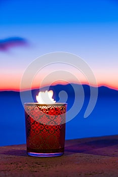 Candle glass at sunset in italy, sea and Elba island, in the background