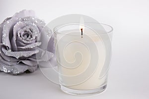 Candle in glass on white background with a rose, product mock-up