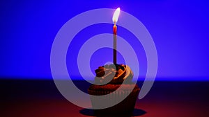 Candle goes out on cupcake in lonely darkness. Concept of birthday, party.