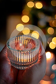 candle in the hands of a woman in a hand on a background of a burning candles