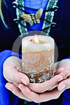 Candle in hands of woman