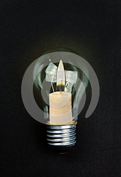 Candle inside light bulb. Earth hour concept