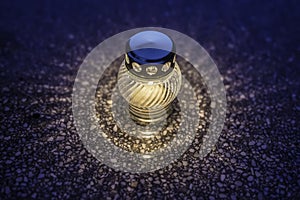 Candle in lampion on graveyard in cemetery at night