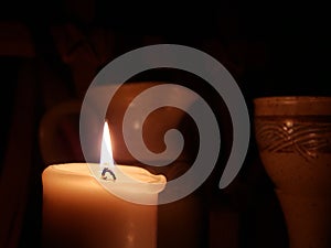 Candle on Left Side with Communion Cup and Pitcher in the backdrop