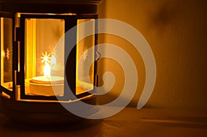 Candle light in beautiful windsheild and shadow on the table beside the wall