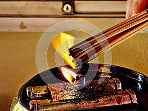 Candle light fire candlestick with burning joss stick incense for Buddhists devotion in shine or temple.