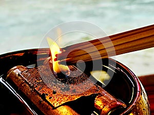 Candle light fire candlestick with burning joss stick incense for Buddhists devotion in shine or temple. Religion