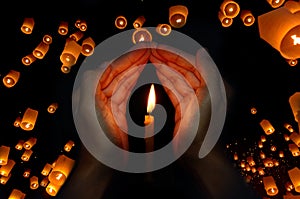 Candle light in hand with Floating lantern in the night sky background