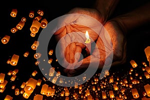 Candle light in hand with Floating lantern in the night sky background photo