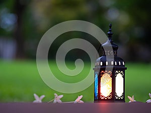 Candle light lids on muslim style`s lantern shining on floor with colorful vintage