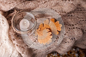 Candle light,pink scarf on a wooden background. Winter cosiness mood, top view, Cozy Winter Autumn Evening