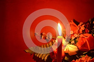 Candle light and roses on red background