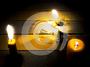 Candle light shining on incandescent bulb photo