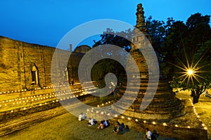 Candle light triple circumambulation around Buddha pagoda temple photo