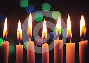 Candle lights in darkness with colorful light effects and bokeh for solemn moments and wallpaper. Candle flame light at night with