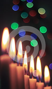 Candle lights in darkness with colorful light effects and bokeh for solemn moments and wallpaper. Candle flame light at night with