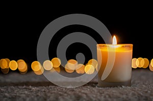 Candle lights in darkness with golden bokeh lights