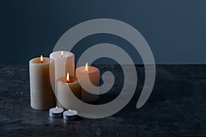 Candle lights in the darkness. Some candles burning in dark background.