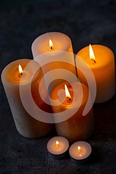 Candle lights in the darkness. Some candles burning in dark background.