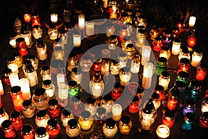 Candle lights on graves and tombstones in cemetery at night in Poland on All Saints’ Day or All Souls’ Day or Halloween