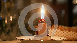 Candle lit on santa claus shape at dinner table christmas night closeup