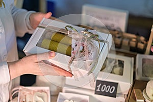 candle maker shares her creation with an eager buyer, surrounded by an array of fragrant candles and artisanal products