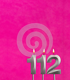 Candle number 112 - Birthday celebration on fuchsia background