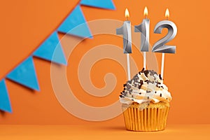 Candle number 112 - Cake birthday in orange background