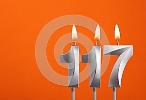 Candle number 117 - Birthday in orange background