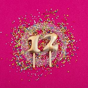 Candle number 12 - Birthday or anniversary on rhodamine red background
