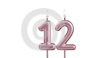 Candle number 12 - Lit birthday candle on white background