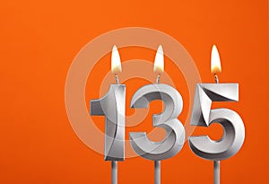 Candle number 135 - Birthday in orange background