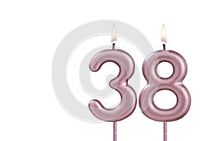 Candle number 38 - Lit birthday candle on white background