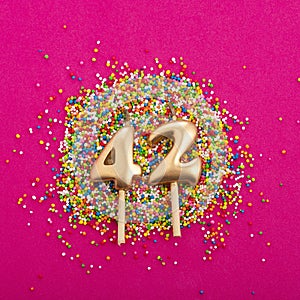 Candle number 42 - Birthday or anniversary on rhodamine red background