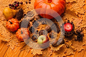 Candle with pumpkins and autumnal decoration