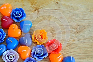Candle roses and candle hearts on wooden background