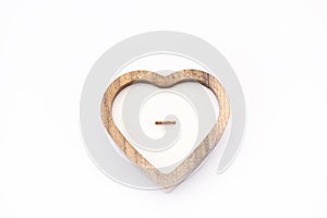 A candle in the shape of a heart. On a white background. A wooden candle