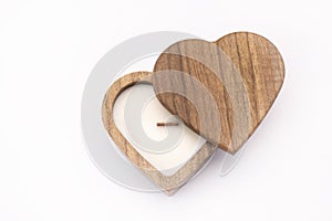 A candle in the shape of a heart. On a white background. A wooden candle