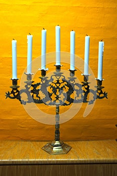 Candle, vintage and holder in church on table at interior of room or cathedral. Wax, brass and retro candlestick for