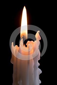 Candleflame on a lit white candle with black background