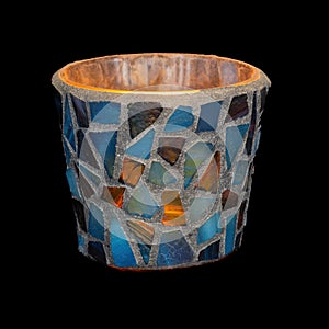 Candlelight glowing in the dark in colorful glass tiled mosaics holder