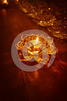 Candlelight in tray rosette on old wooden.
