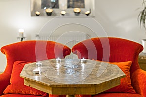 Candles on a antique side table with intarsia and red chair