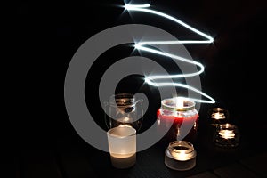 Candles on a black background. Glowing light curve. Light painting photography. Magical still life.