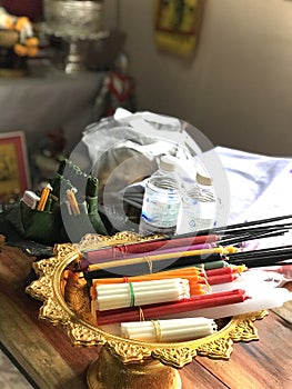 Candles, black incense, water bottles, and other items used in religious ceremony