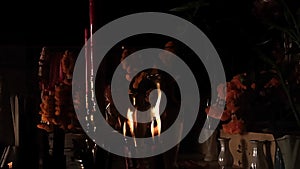Candles burn in a dark Asian temple in slow-motion