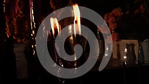 Candles burn dramatically in a dark Asian temple in slow-motion