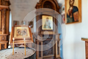 Candles burn in front of the iconostasis and the cross with a crucifix