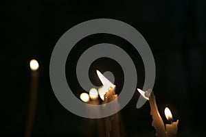 The candles burning bright in the dark historical monastery - church in Armenia